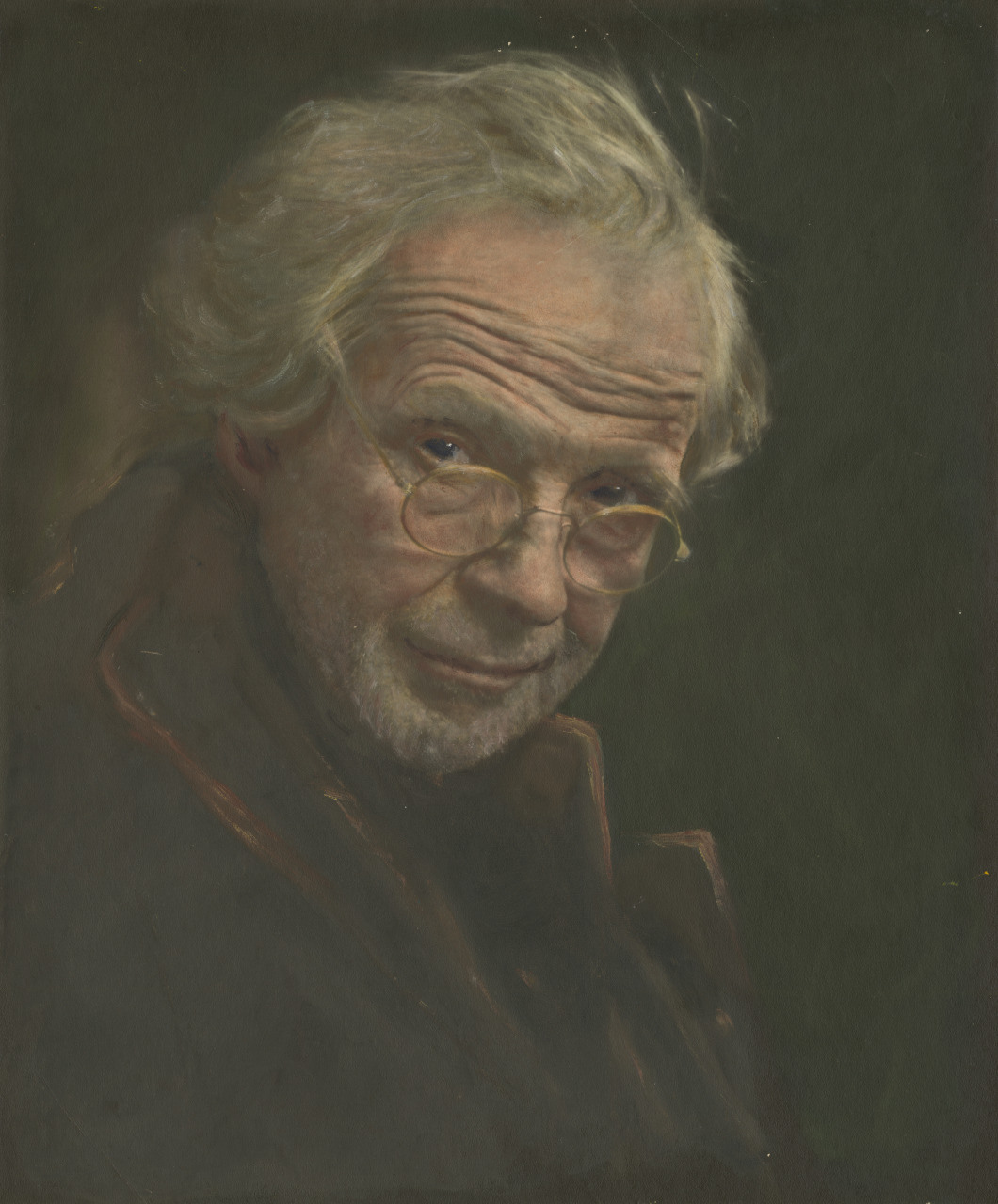 An elderly man with wavy white hair and wire-rimmed glasses gazes intently. Hes wearing a dark coat with an upturned collar against a dark background.