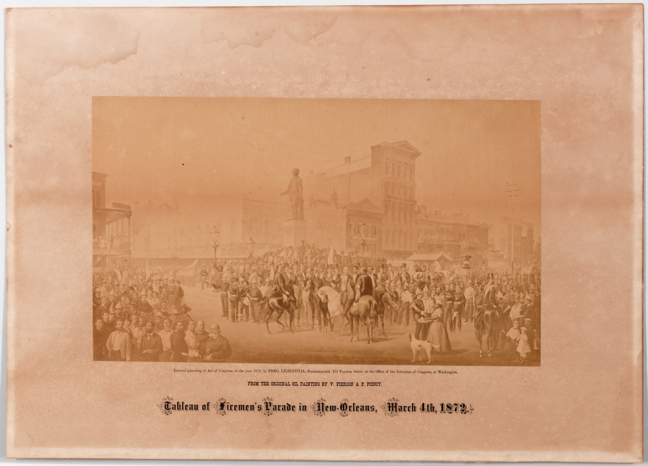 Sepia-toned image of a large crowd gathered in a city square for a parade. People are on horseback and on foot, surrounded by historic buildings. The text at the bottom reads, Tableau of Firemen’s Parade in New Orleans, March 4th, 1872.