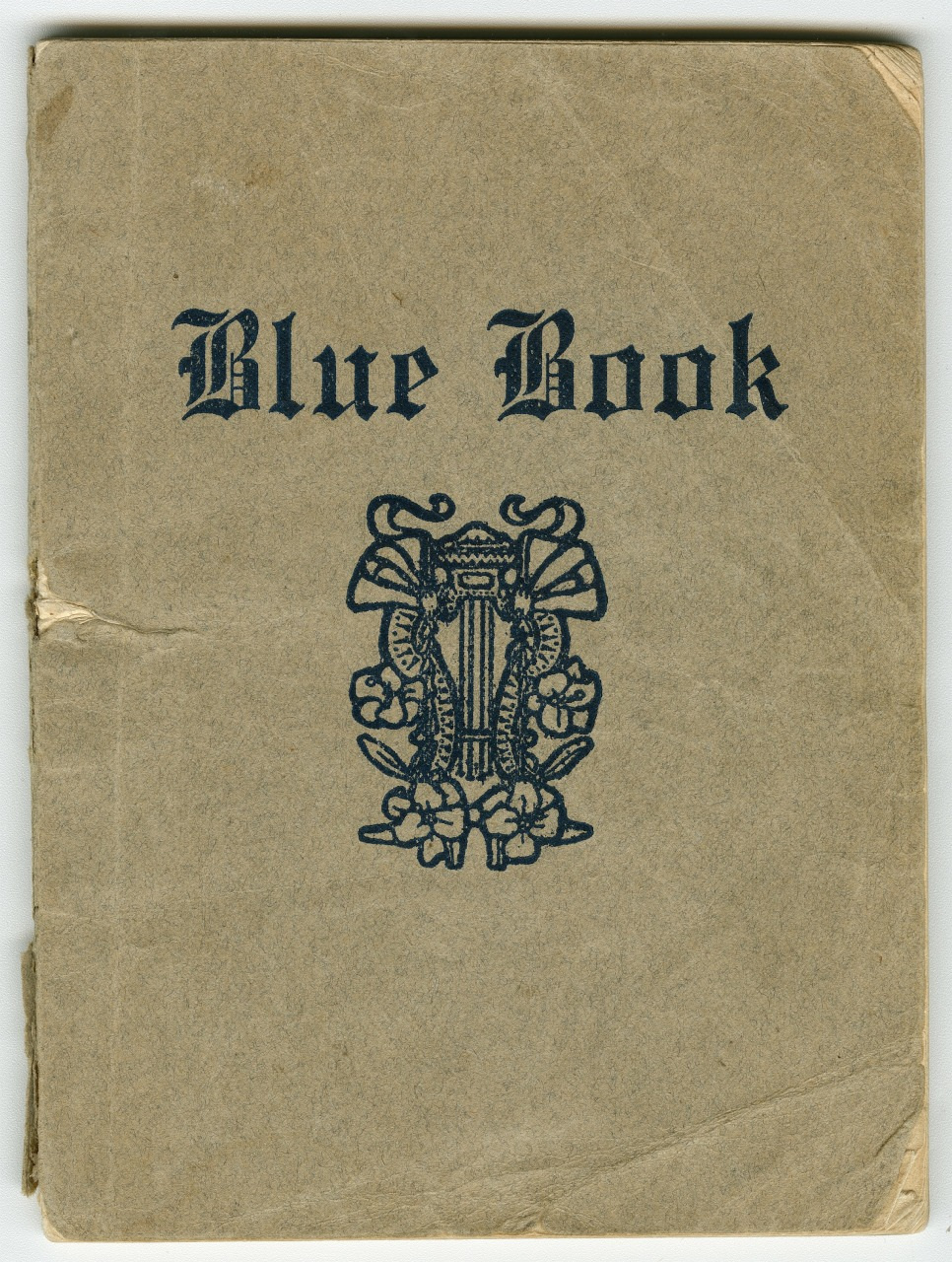 Cover of a small, vintage booklet titled Blue Book, featuring ornate, dark blue typography and a decorative design resembling flowers and leaves in the center. The paper appears aged and worn.