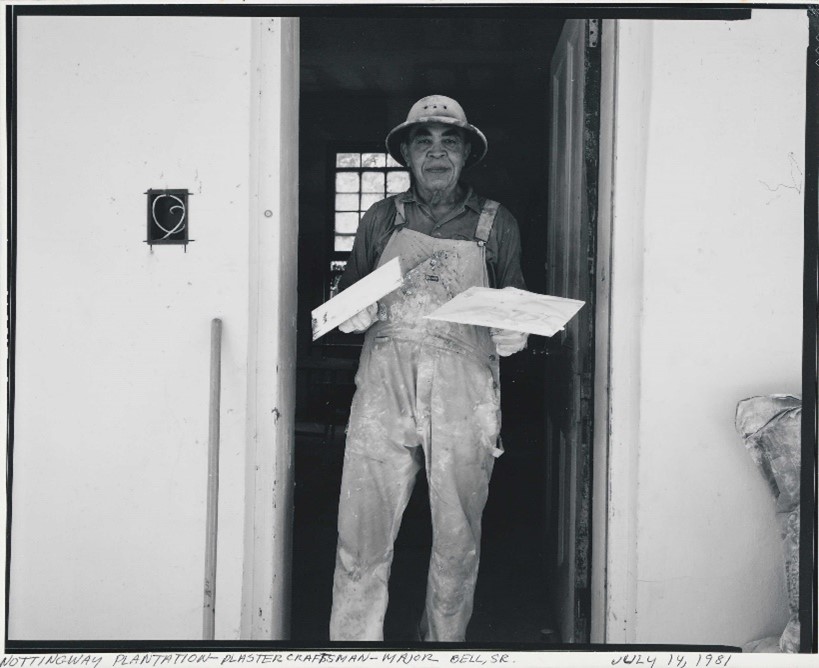 A black and whtie photo of Nottoway plantation worker Major Bell Sr., standing in a doorway with painting supplies.