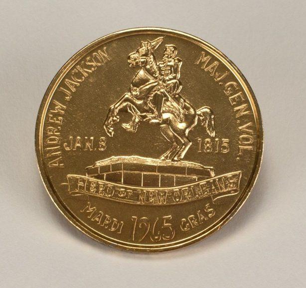 A gold coin featuring an image of Andrew Jackson on horseback, with inscriptions around the edge and Field of New Orleans, Jan. 8, 1815, and 1963 Gras at the bottom.