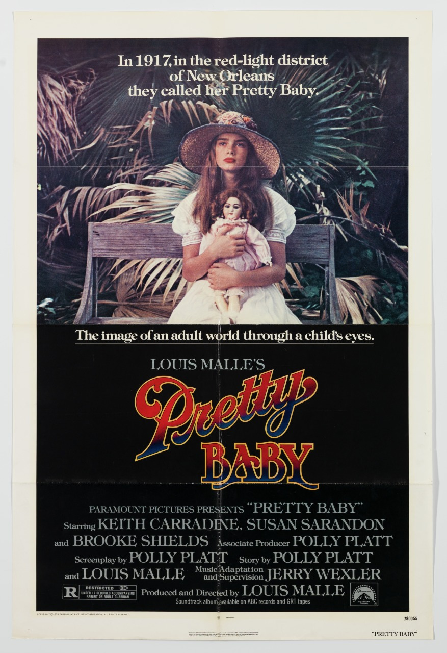 A vintage movie poster for Pretty Baby featuring a young girl with long brown hair holding a doll. She sits on steps surrounded by greenery. The text highlights the red-light district of New Orleans in 1917.