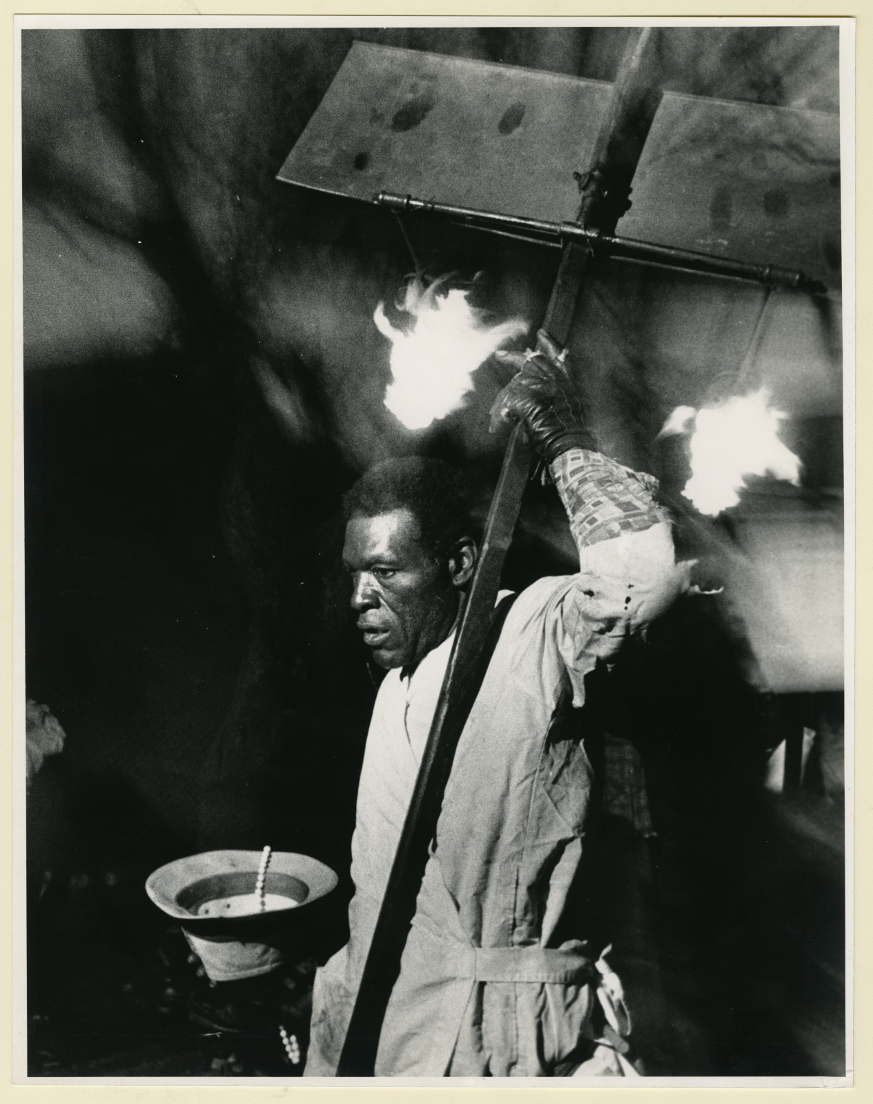 Black and white photo of man carrying a flambeaux.