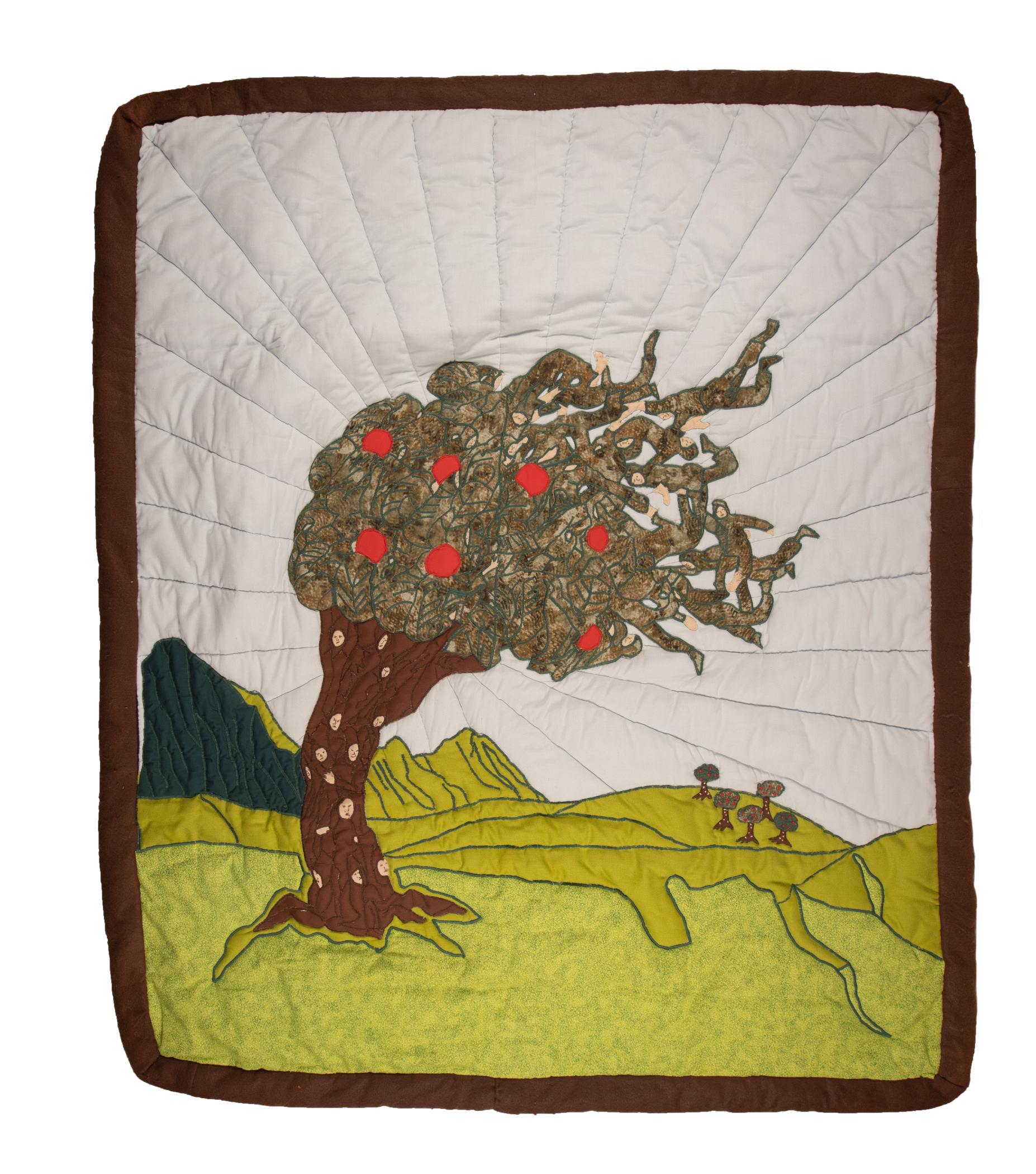 A quilt depicting a tree with red apples, green leaves, and a brown trunk, set against a green landscape with distant mountains and blue sky. The quilt is bordered in brown.