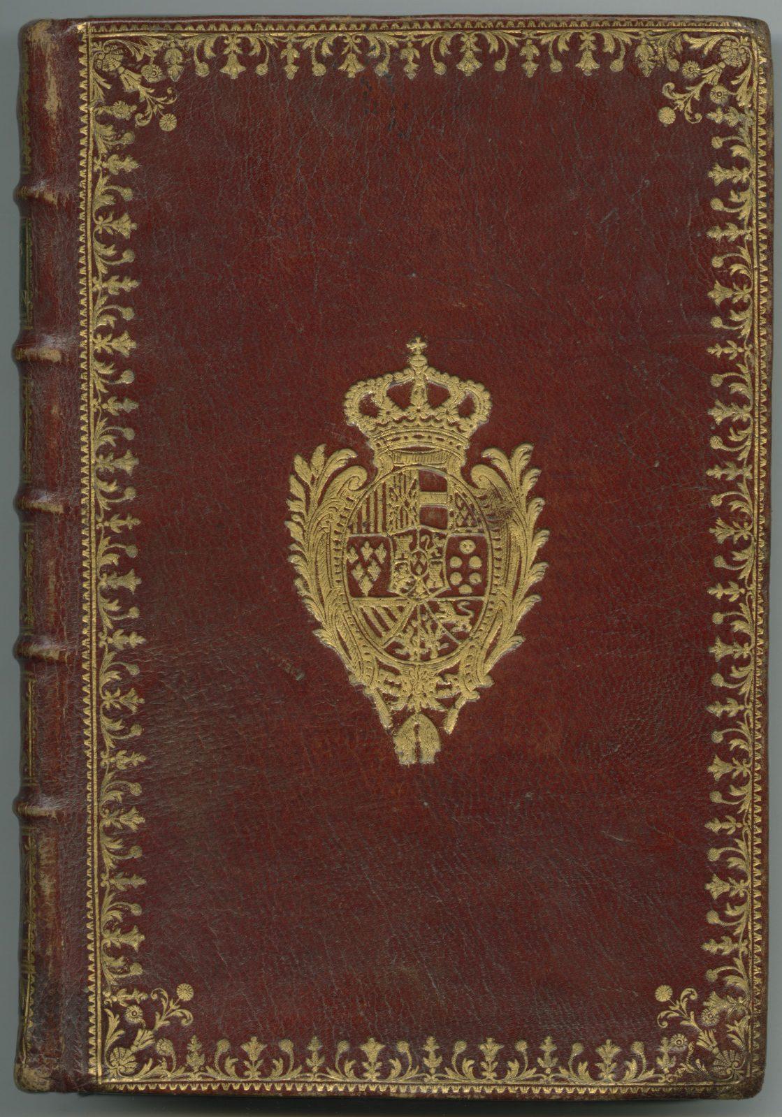 A vintage red leather book cover adorned with ornate gold detailing. The center features an intricate coat of arms with a crown on top, surrounded by decorative floral patterns. The spine has raised bands, adding to its antique appearance.