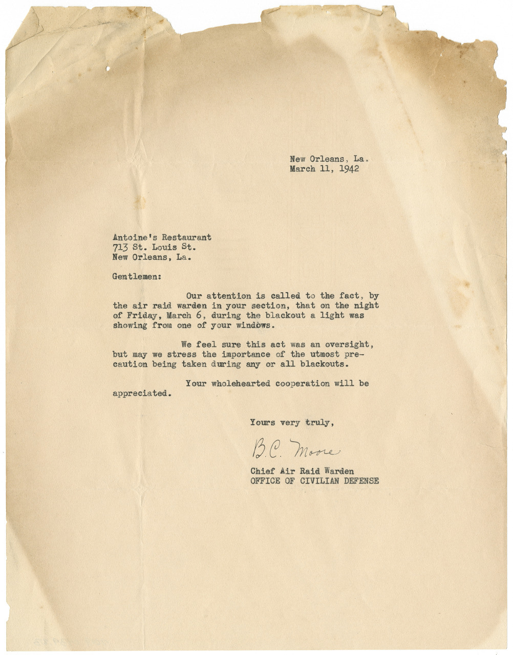 A vintage typed letter dated March 11, 1942, from B.C. Monroe, Chief Air Raid Warden, addressing Antoines Restaurant in New Orleans. It mentions a light infraction during a blackout on March 6 and requests better compliance in the future.