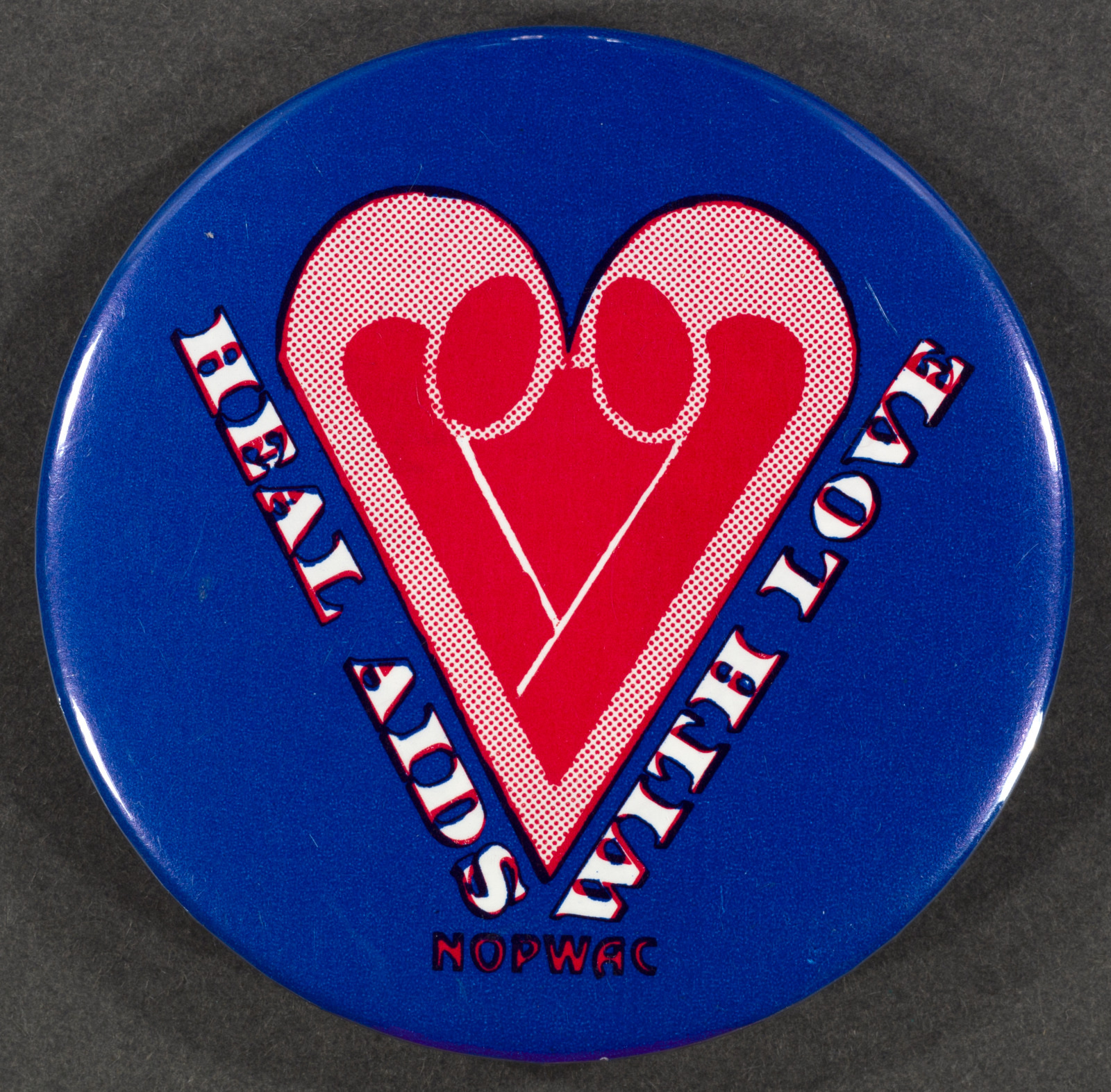 A round blue button features a pink heart design with the text HEAL AIDS WITH LOVE and NOPWAC written around it.