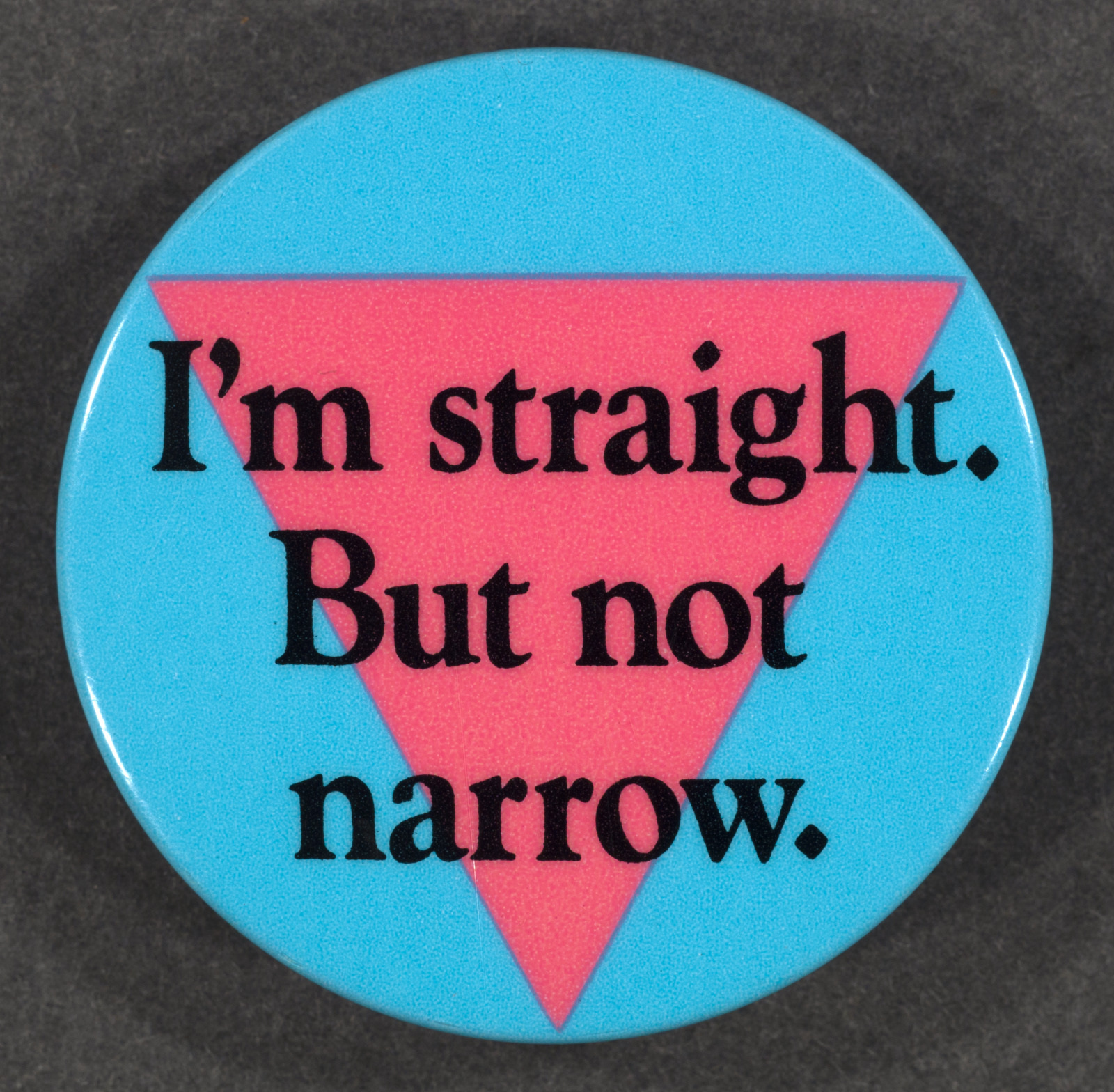 A round button with a blue background features a pink triangle and the text I'm straight. But not narrow. printed in black letters.