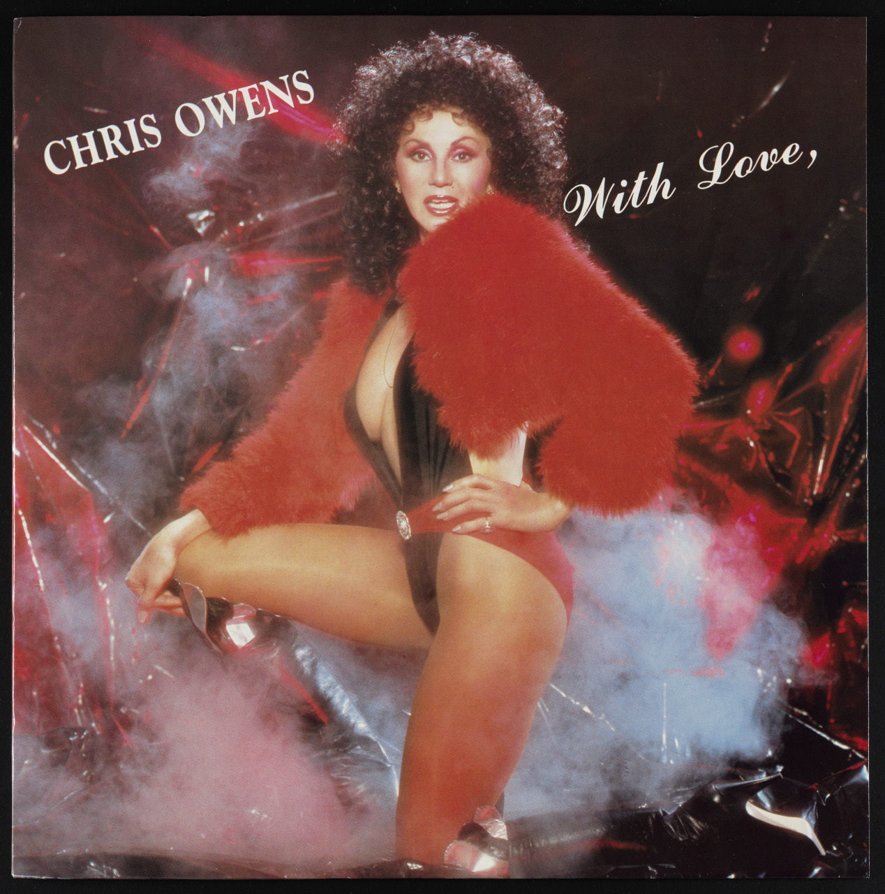 A person with curly hair poses confidently in a black outfit with a red feathered jacket, set against a dramatic background of red and silver reflective material, with text Chris Owens With Love in the upper corners.