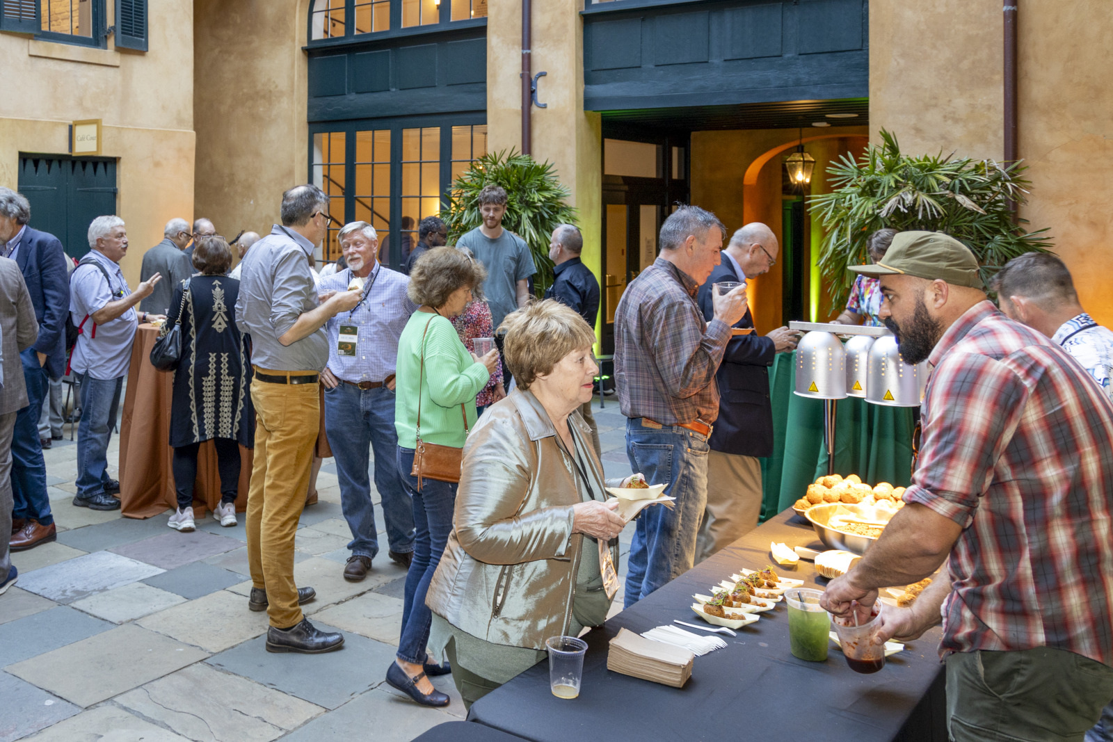 Attendees of Food Forum at HNOC enjoy food and beverages in a historic courtyard.