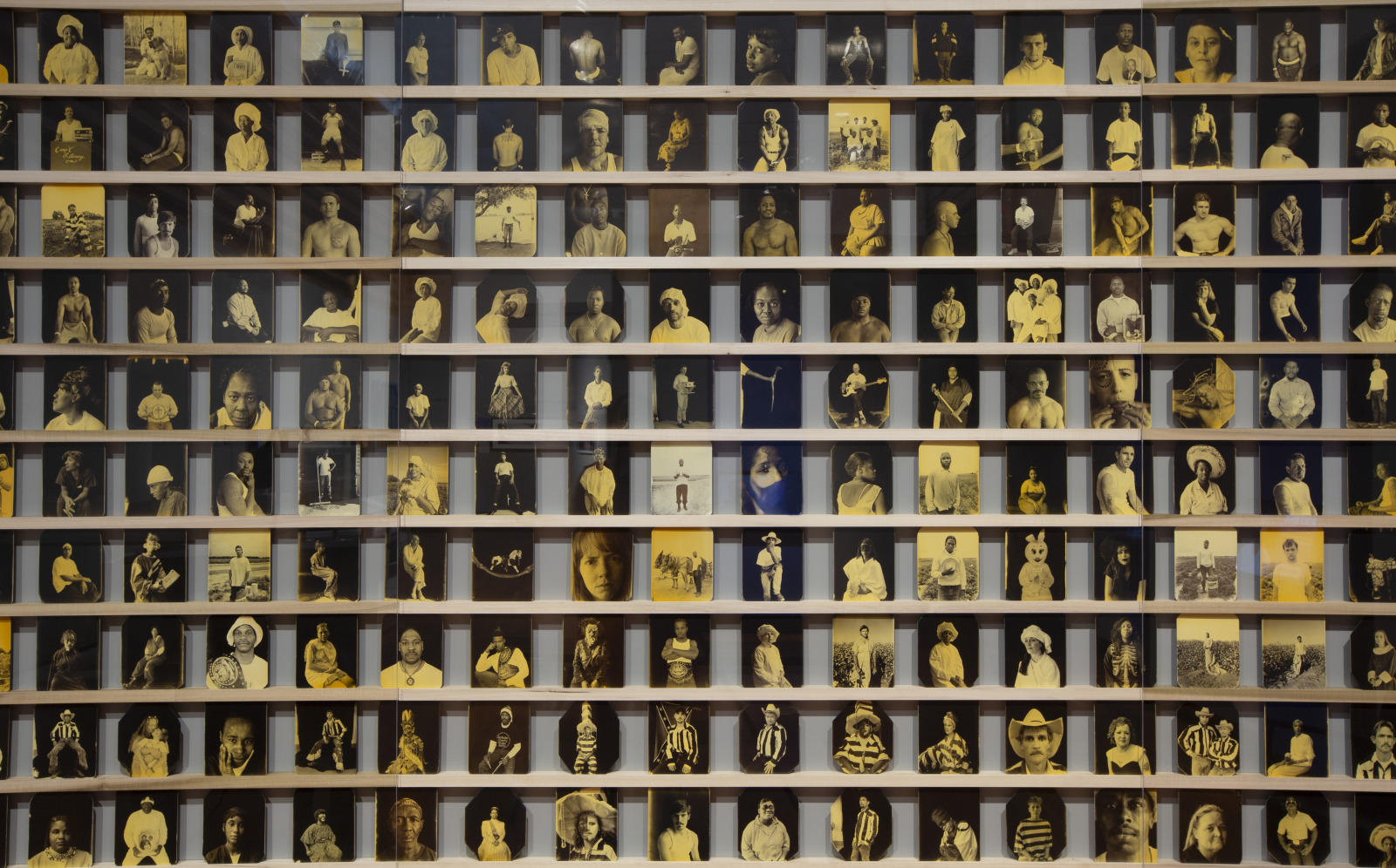 A photograph shows hundreds of portraits of incarcerated people, printed on metal plates that were published in the book "One Big Self: Prisoners of Louisiana," by Deborah Luster.