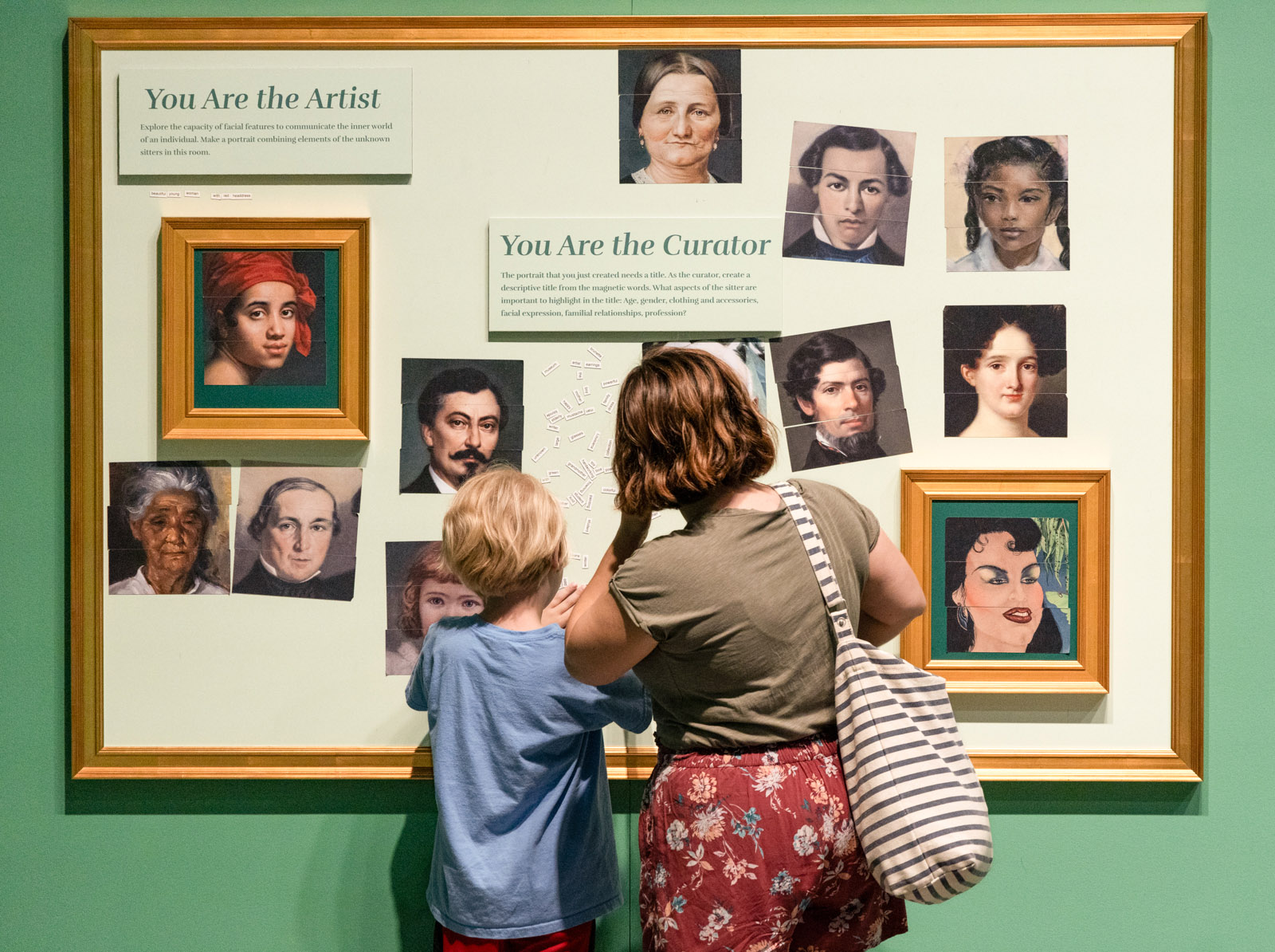 A woman and a child examine a wall display at a museum while enjoying free events in New Orleans at the Historic New Orleans Collection. The woman points to a central diagram on the wall.