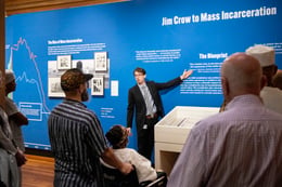 A tour guide gestures towards an exhibition display at HNOC.