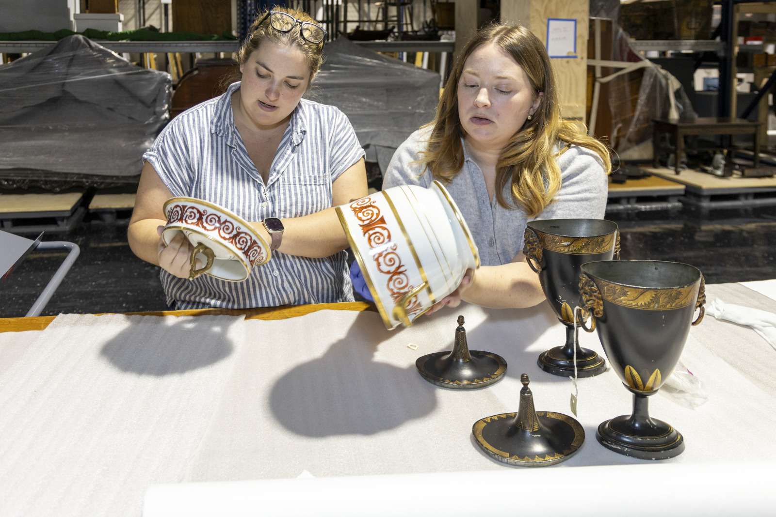 Lydia Blackmore and Kristin Hebert Veit examine a porcelain urn at HNOC’s off-site storage facility.