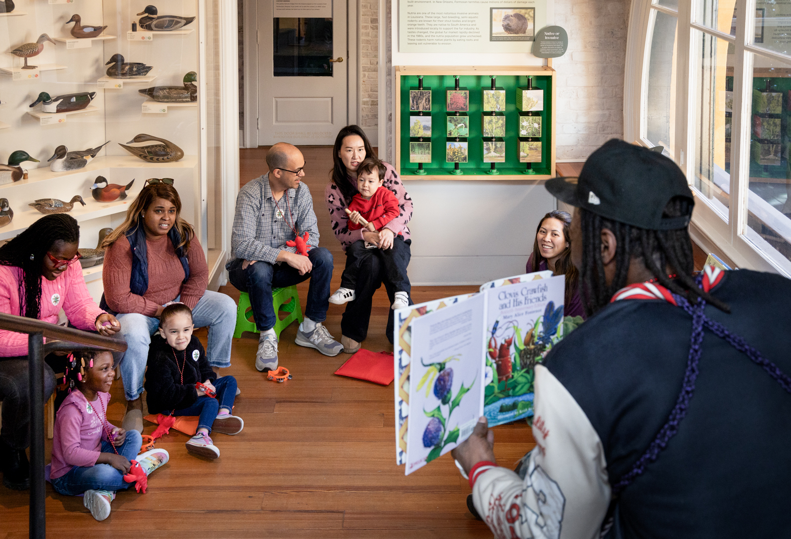 A group of children and their families participate in a program at HNOC.