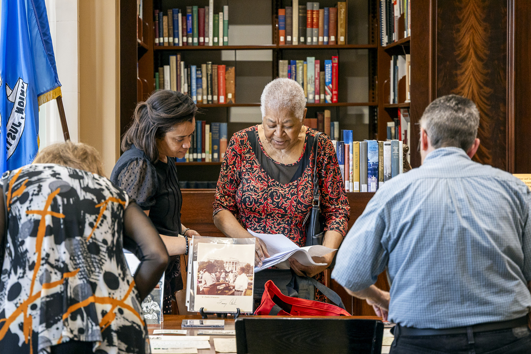 A group of people examine historical materials at HNOC's Williams Research Center.