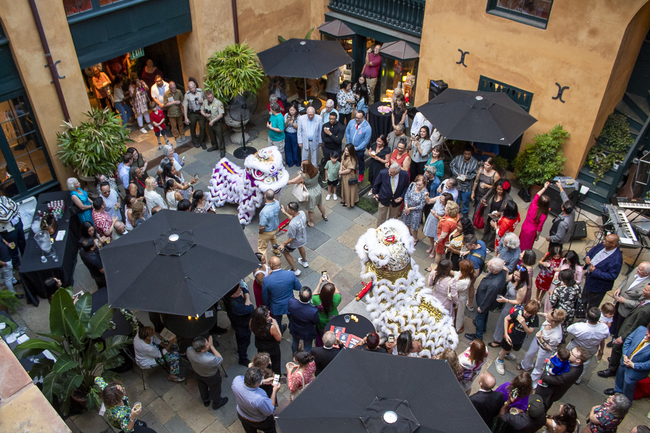 A view from above shows an opening reception inside HNOC's 520 Royal Street courtyard, with more than one hundred guests in attendance.