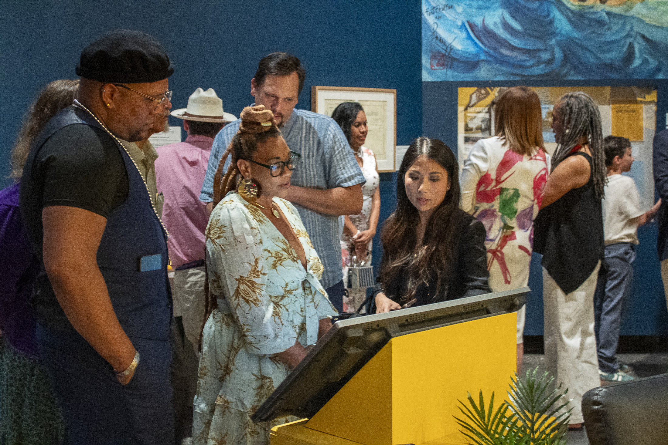 A group of museum visitors explore "Making It Home: From Vietnam to New Orleans".