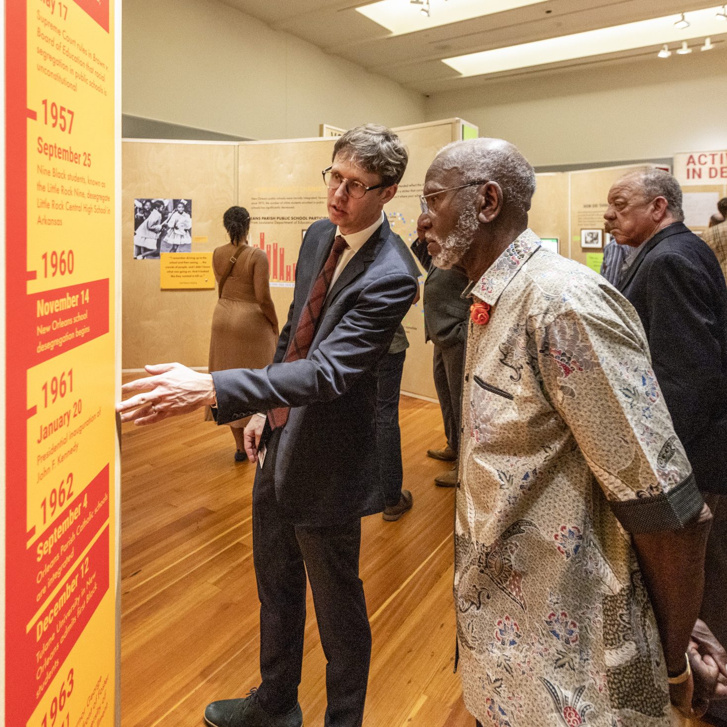 A group of museum visitors explores an exhibition at HNOC, led by a staff member giving a tour.