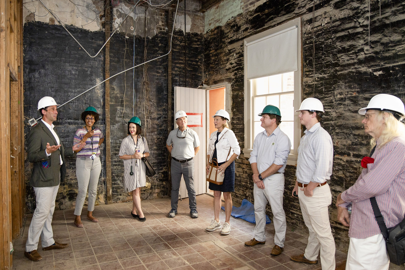 A group of visitors take part in a hard hat tour of spaces being renovated at 533 Royal Street.