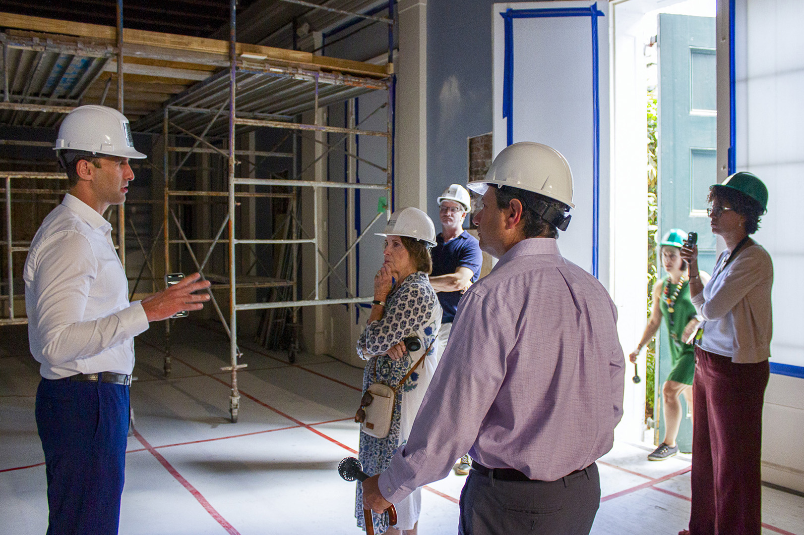 A group of people participates in a hard hat tour of the renovation of 533 Royal Street.