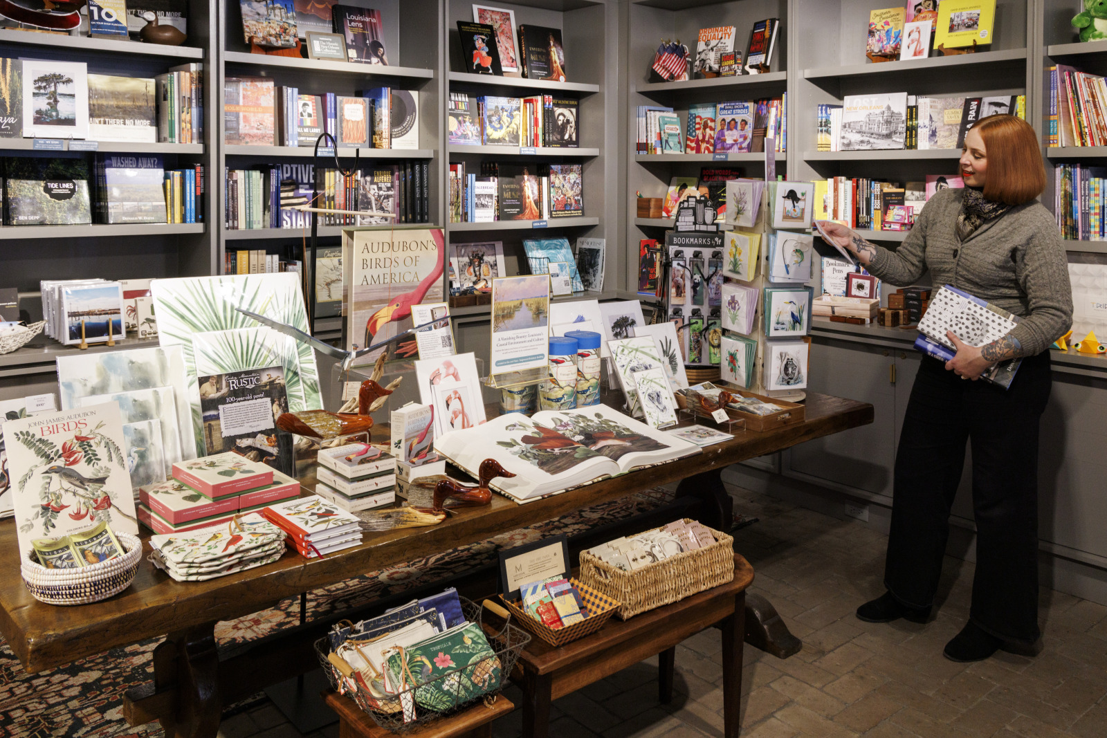 Interior view of the Shop at the Historic New Orleans Collection. A shopper is looking at greeting cards on the right side of the image.