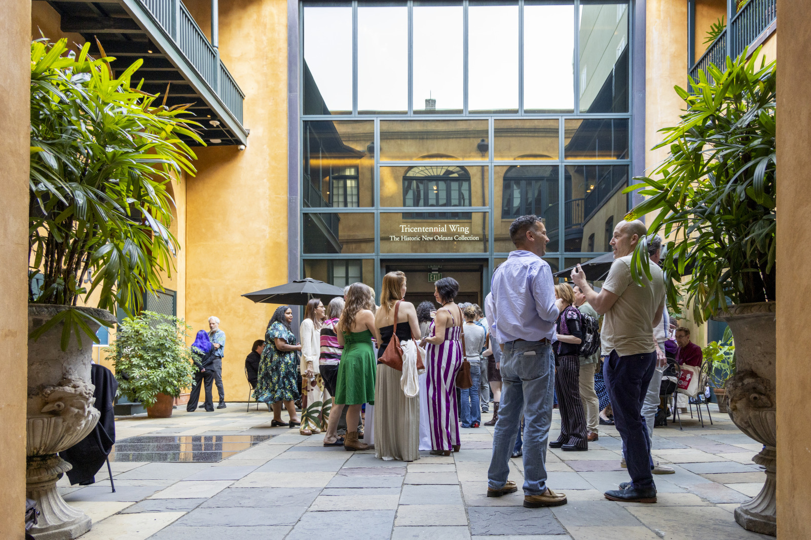 Visitors converse in HNOC's courtyard at 520 Royal Street