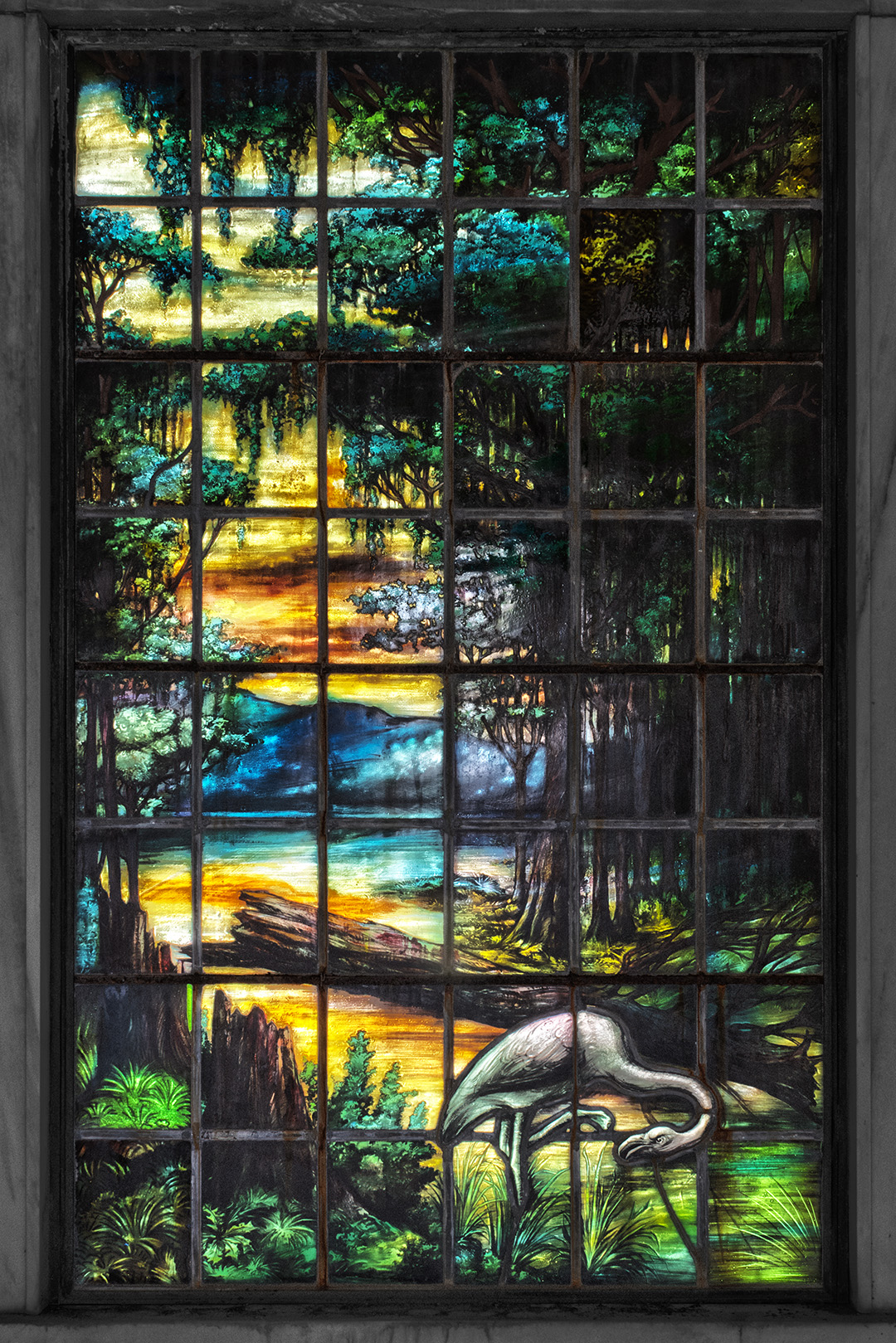 Stained glass window depicting a marshland scene including cypress trees and an egret, located at Dibert Mausoleum at Metairie Cemetery.
