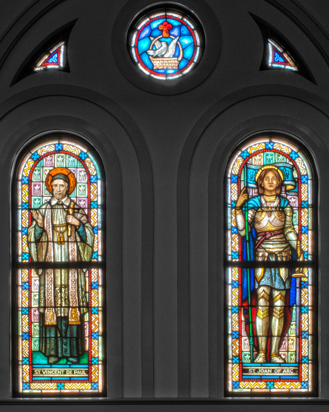 Photo of two adjacent stained glass windows at Most Holy Trinity Catholic Church in Covington, Louisiana.