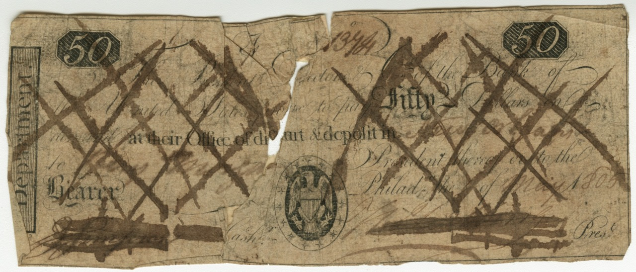 A worn and torn antique banknote with 50 marked in the corners. The surface is heavily marked with crossed lines and scribbles. Text is faded and partially illegible, with an emblem visible near the bottom.