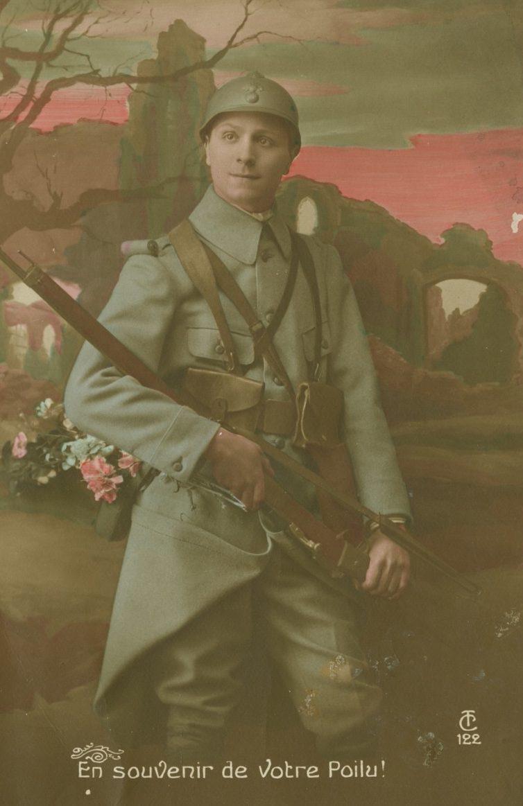 A World War I French soldier in uniform, holding a rifle, stands with a serious expression against a backdrop of ruins and a sunset sky. The bottom text reads, En souvenir de Votre Poilu!.