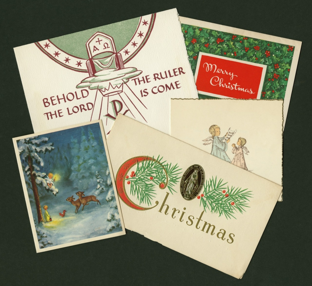 A collection of vintage Christmas cards is displayed. One card features a religious motif with a nativity star, another says Merry Christmas, and others depict festive scenes with deer and angels. They are arranged on a dark green background.
