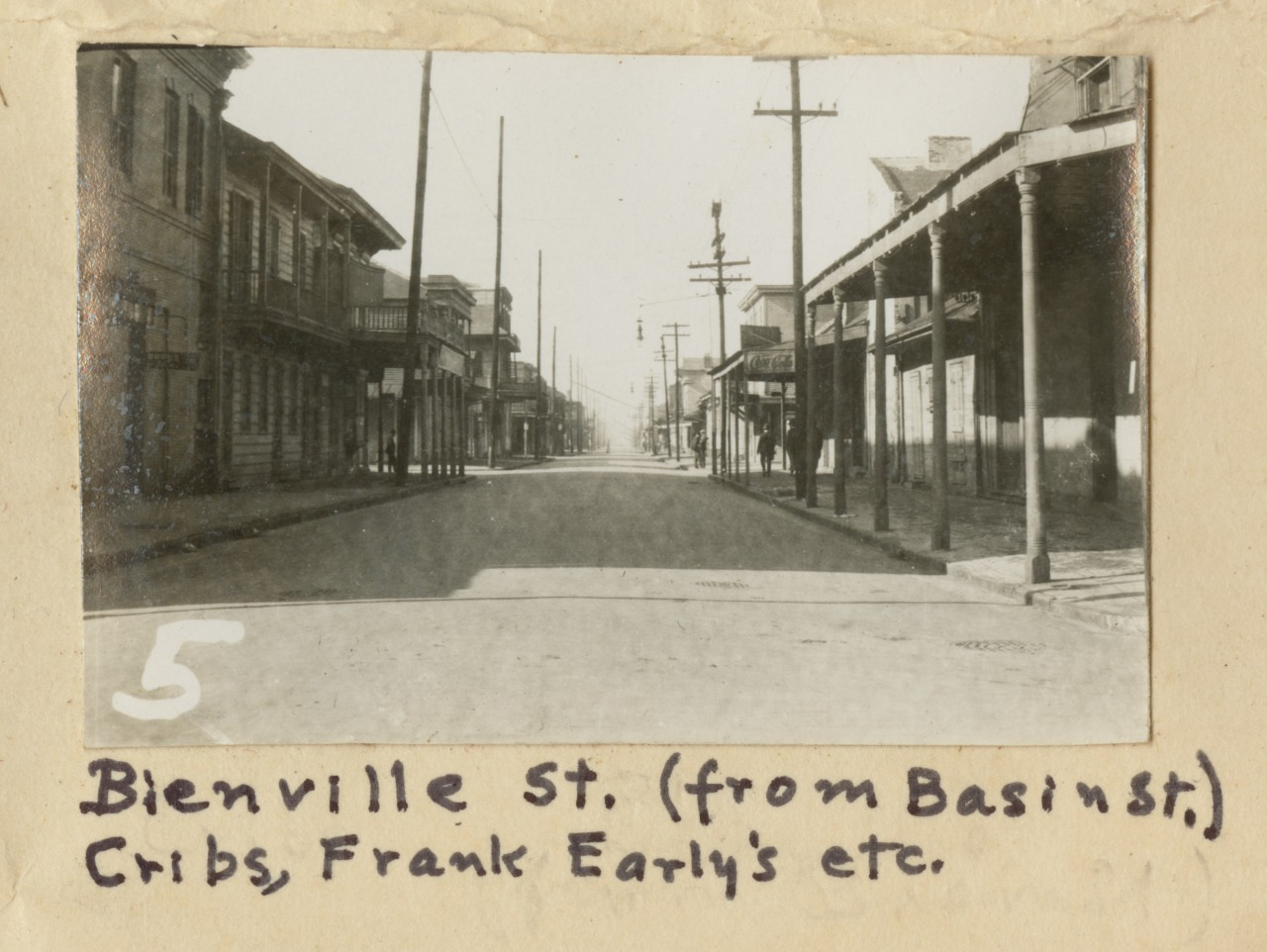 Black and white photo of Bienville Street from Basin Street, featuring old buildings and empty road. Handwritten caption mentions Cribs, Frank Earlys etc. A large number 5 is on the left of the image.