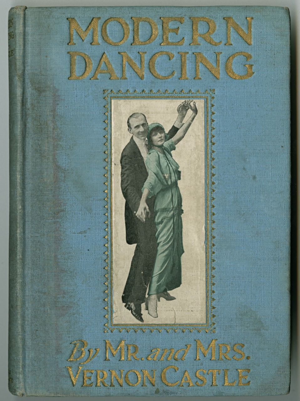 The cover of a book titled Modern Dancing, featuring an image of a couple dancing. The man is in a suit and the woman wears a long dress. The authors are Mr. and Mrs. Vernon Castle. The cover is light blue with gold lettering.