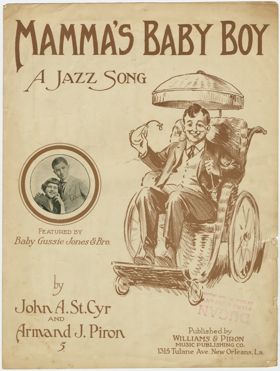 Vintage sheet music cover titled Mammas Baby Boy: A Jazz Song featuring a drawing of a smiling man in a wheelchair, surrounded by an umbrella, with an inset photo of two children titled Baby Gussie Jones & Bro. Published by Williams & Piron.