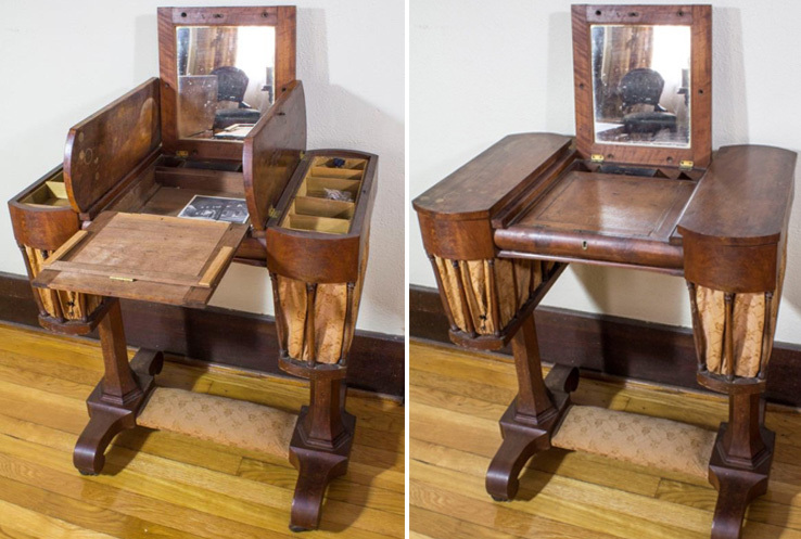 A wooden antique sewing table with a built-in mirror. The table has compartments and a fold-out section for organizing sewing supplies. It features a rich, polished finish and tapered legs, showcasing a classic design.
