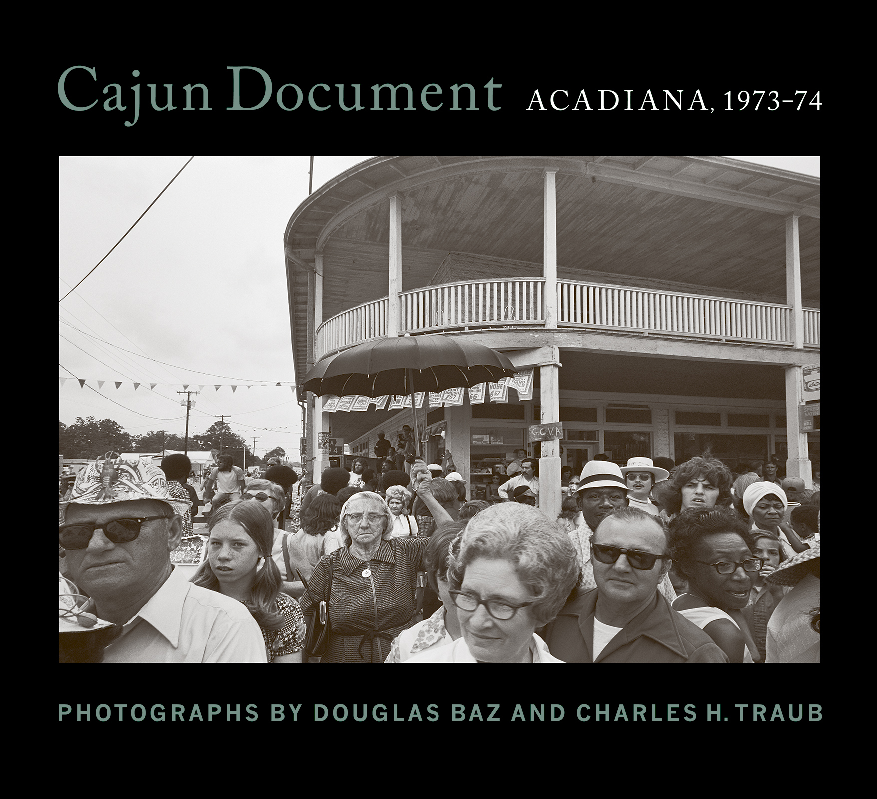 A black and white photo captures a crowd of people outside a vintage building. Many wear sunglasses and hats, while some hold umbrellas. The scene is lively, with a mix of adults and children. Text above and below highlights a photo exhibit by Douglas Baz and Charles H. Traub.