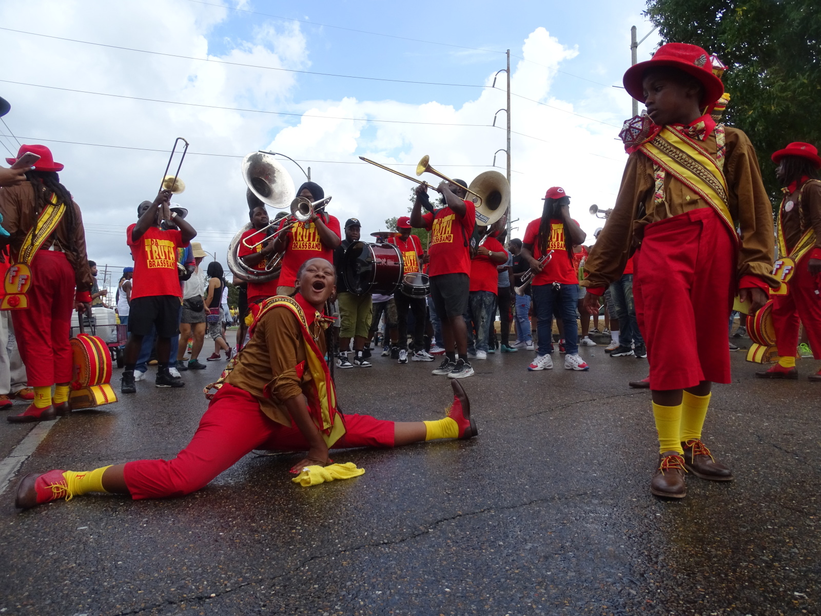 Jazz Henry of Footwerk Family does the splits on the street in front of Da Truth Brass Band at the Family Ties second line parade.