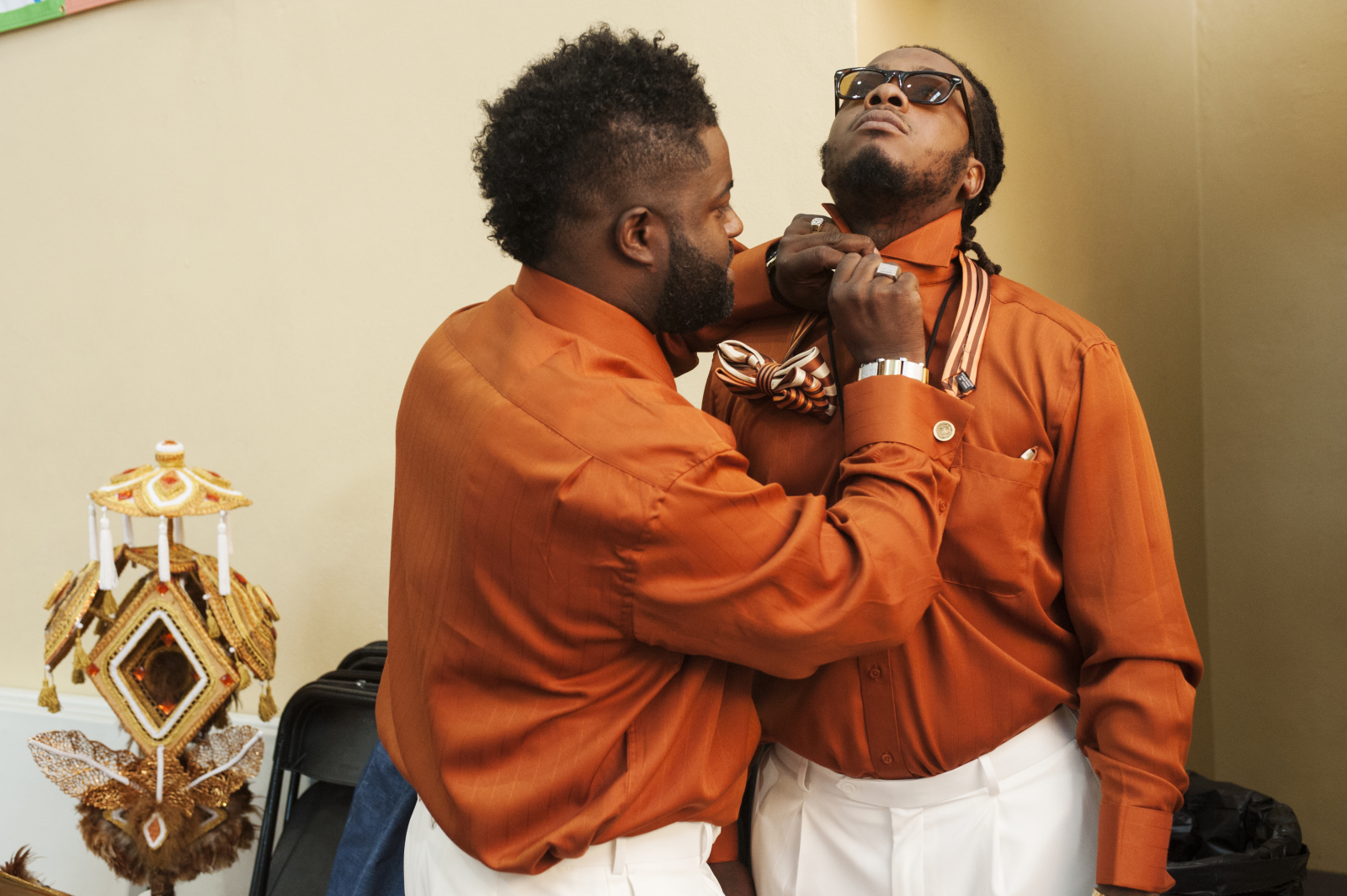 Keelian “Dump” Boyd Sr. buttons the collar of a fellow club member as they get ready to parade.