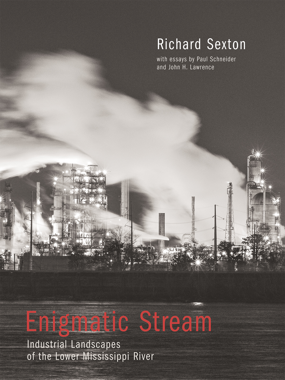 A black and white book cover titled Enigmatic Stream by Richard Sexton, featuring a glowing industrial facility with smoke against a night sky. Text mentions essays by Paul Schneider and John H. Lawrence, focusing on the Lower Mississippi River.