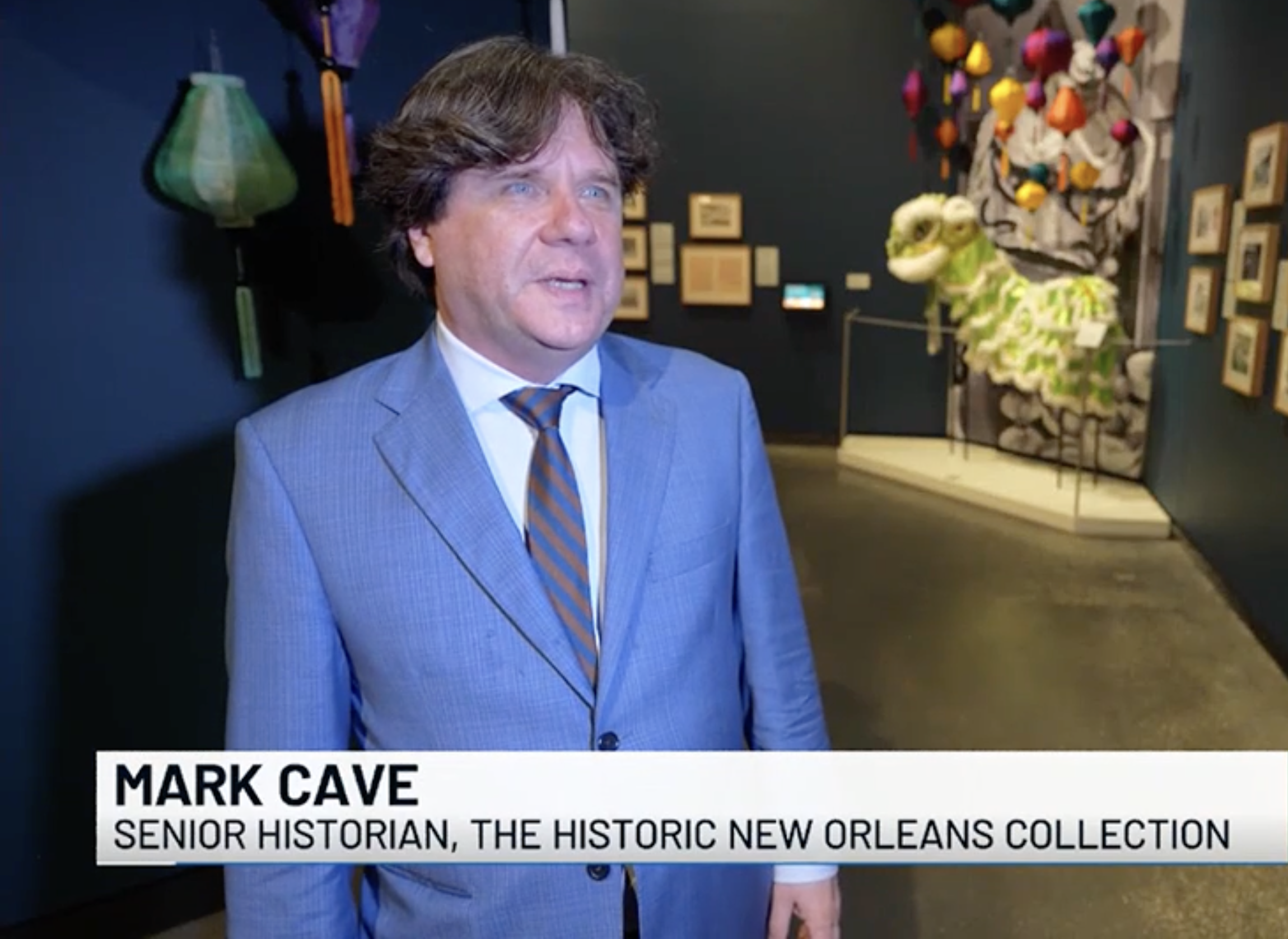 A screenshot from an interview conducted by Fox 8 New Orleans with Mark Cave, HNOC senior historian. The exhibition "Making It Home" can be see behind him.
