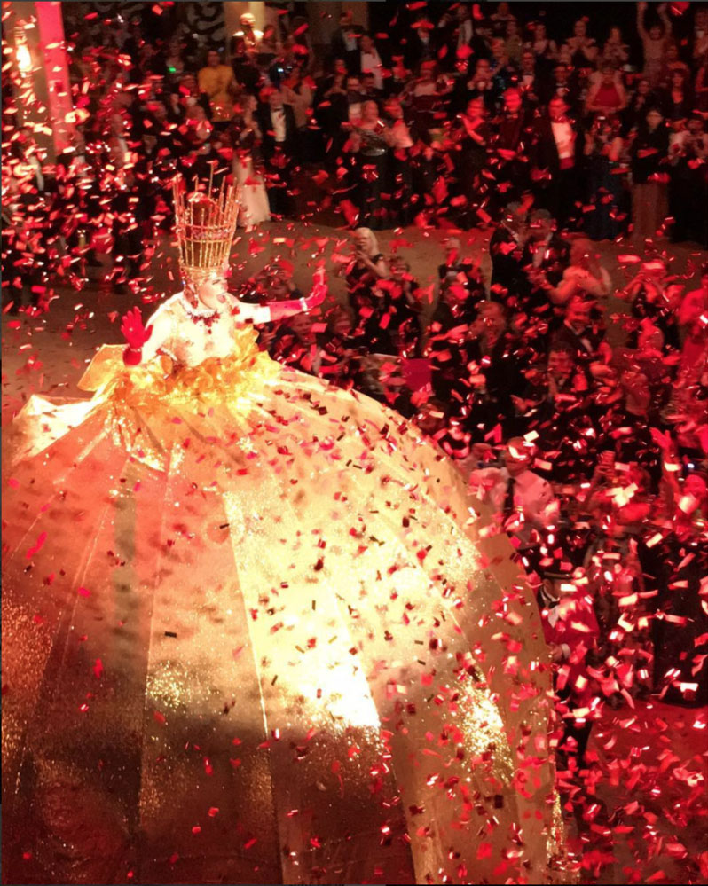 A photo of the Queen of the 2018 Krewe of Armenius Ball, as the Krewe celebrated their 50th anniversary. Confetti can be seen falling from the ceiling.