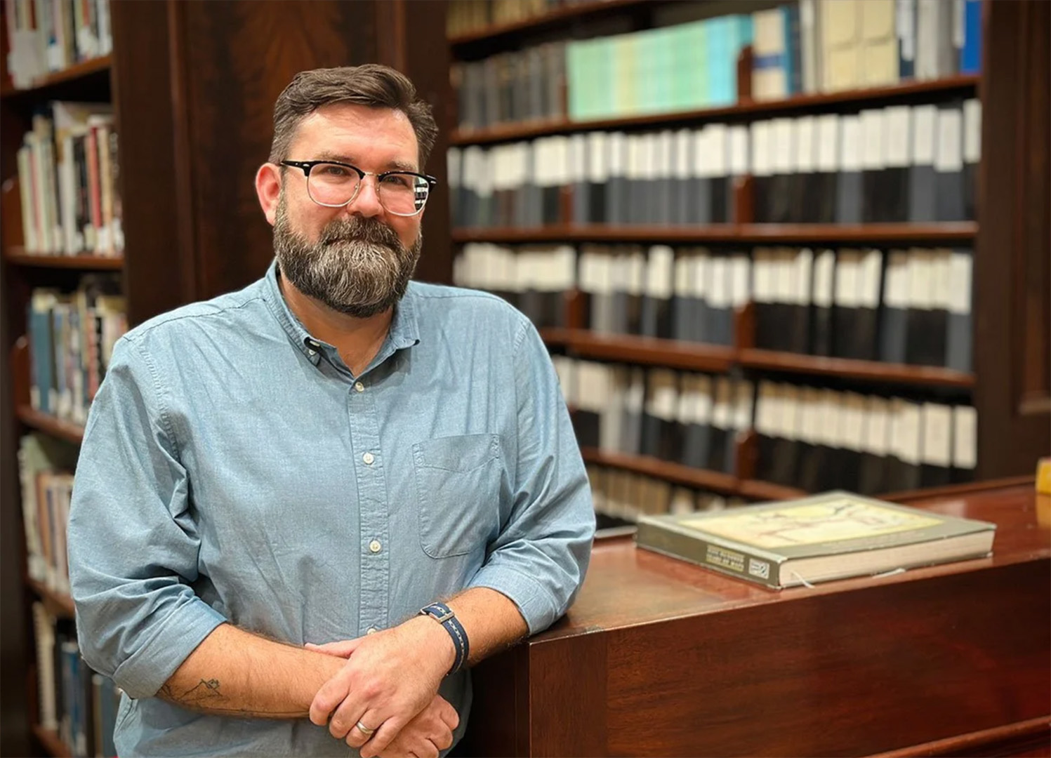 Kent Woynowski, HNOC’s manager of digital assets and initiatives, standing in front of the survey binders in the Williams Research Center.