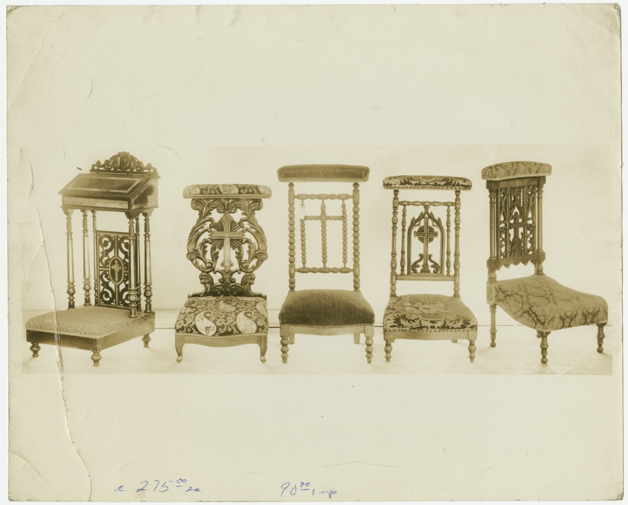 A sepia-toned vintage photograph of five ornate wooden chairs with intricate carvings and upholstered seats, each displaying unique designs, arranged in a row on a plain backdrop.