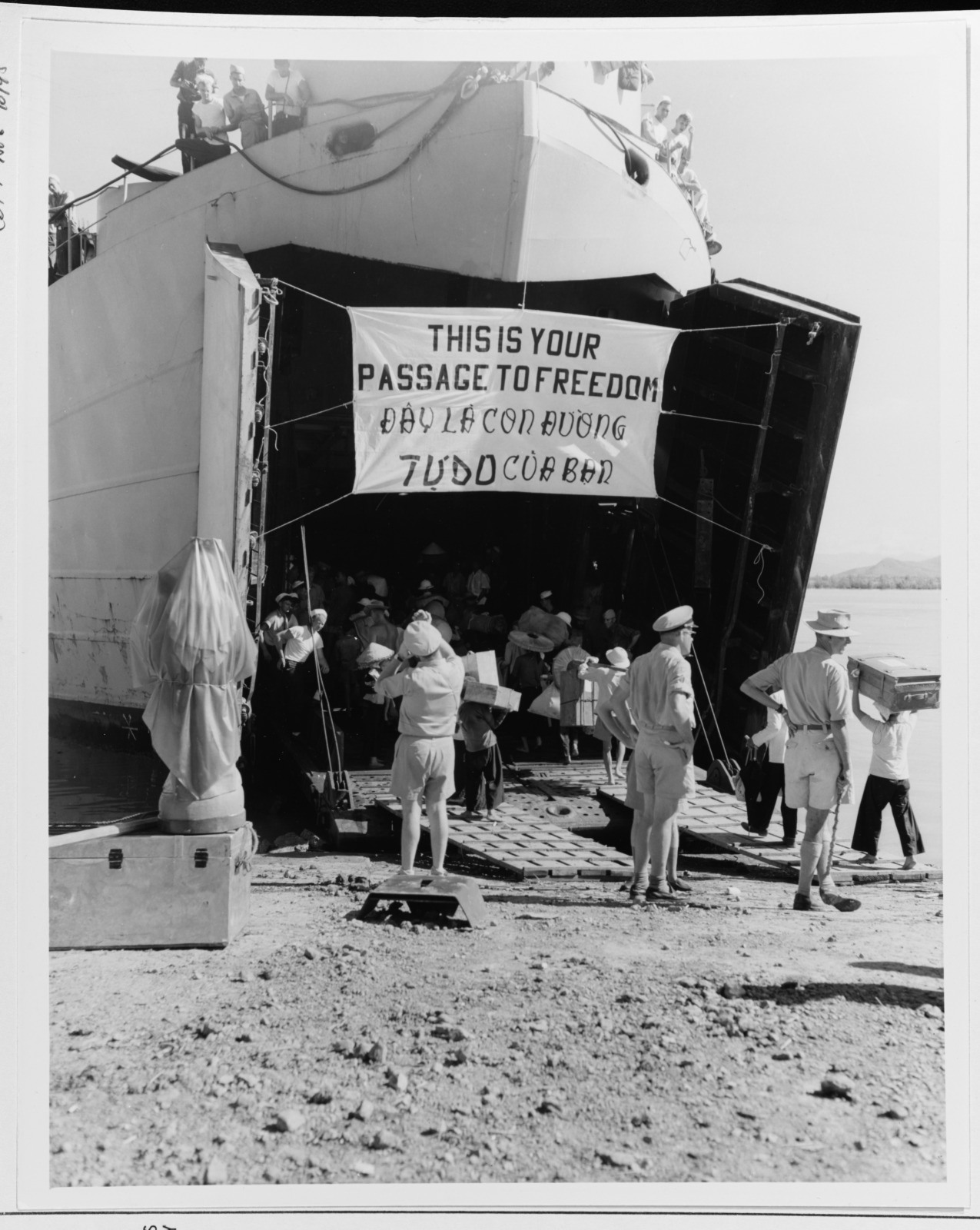 A ship docked with a banner reading This is your passage to freedom. People are disembarking, with several individuals standing nearby. The foreground shows a few soldiers in uniform observing the scene. The environment appears dusty and arid.