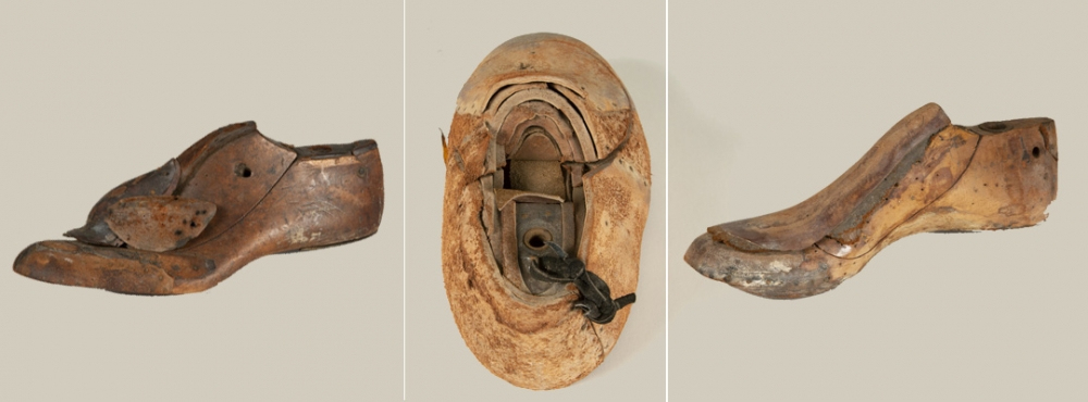 Three views of an old, worn wooden shoe last including side, bottom, and top angles. The shoe last shows signs of age, with cracks and weathering visible on its surface. The sole view reveals an attached loop of black cord.