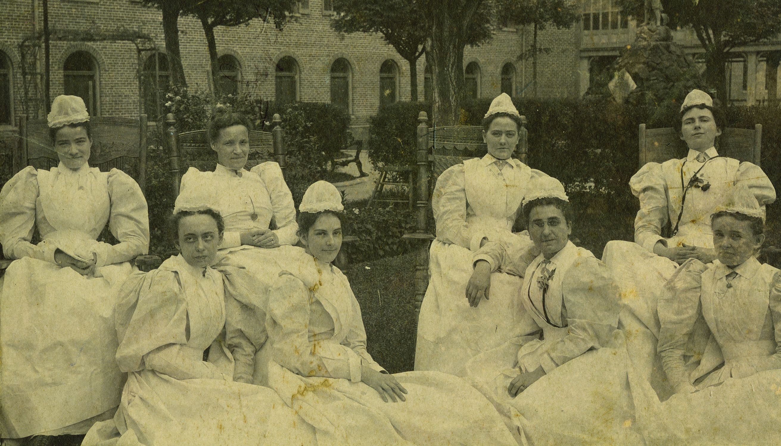 A group of posed nurses in a sepia-tone photograph.