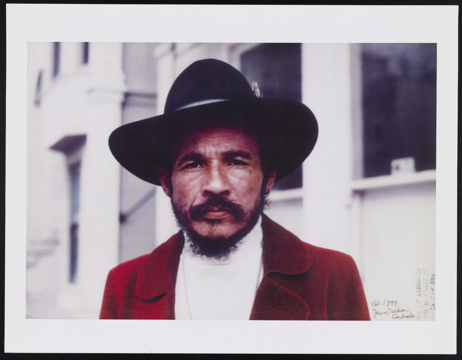 A photo of Bob Kaufman taken in 1979, wearing a black fedora and red jacket.