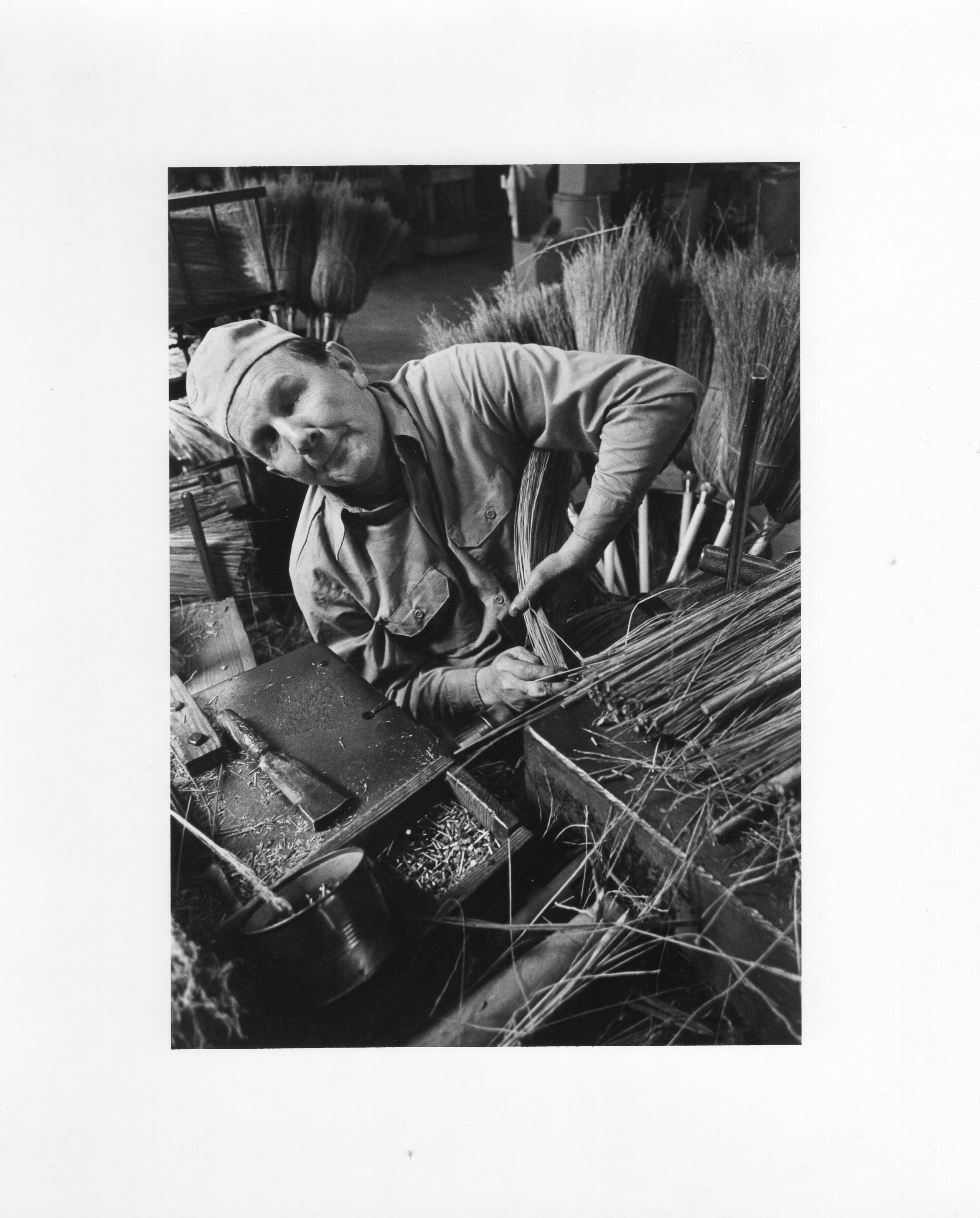A man makes brooms at Lighthouse for the Blind.