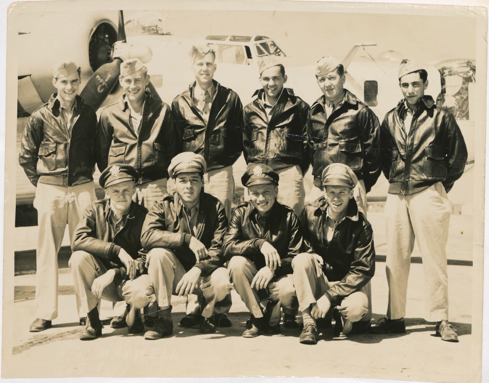 A sepia tone photo shows Cervantes posing with his nine fellow aircraft crewmates at Mountain Home Air Force Base in Idaho in 1944. Their B-24 Liberator bomber can be seen parked in the background.